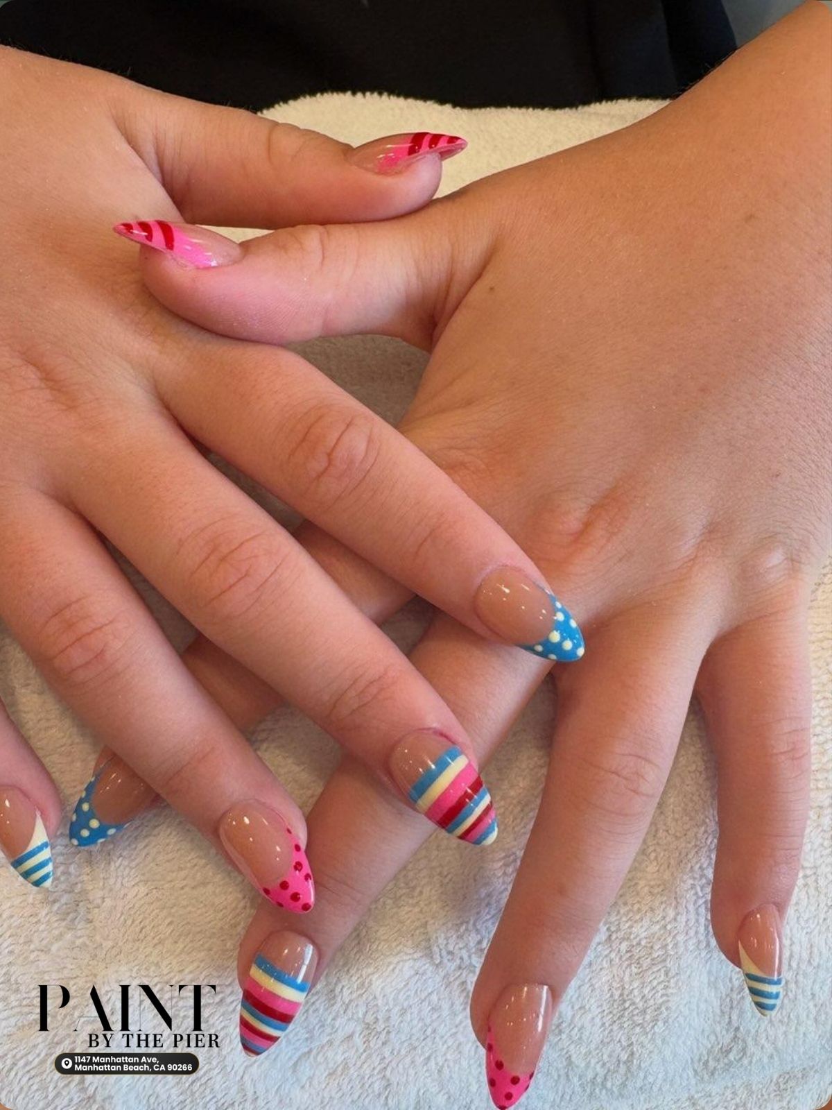 Whimsical mismatched nail art featuring black and white polka dots and stripes