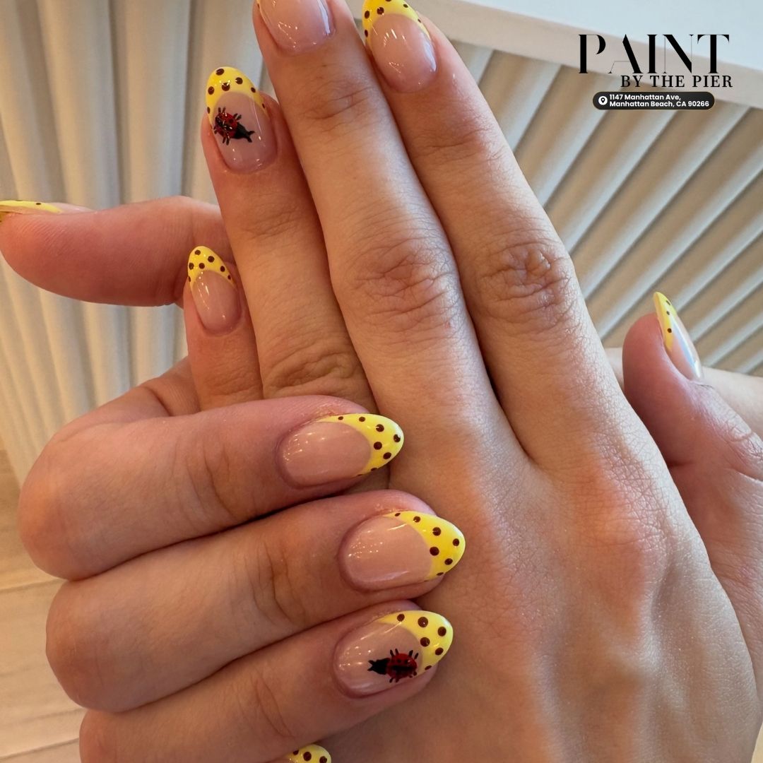 Bright yellow polka dot french tips with miniature red ladybug accent art